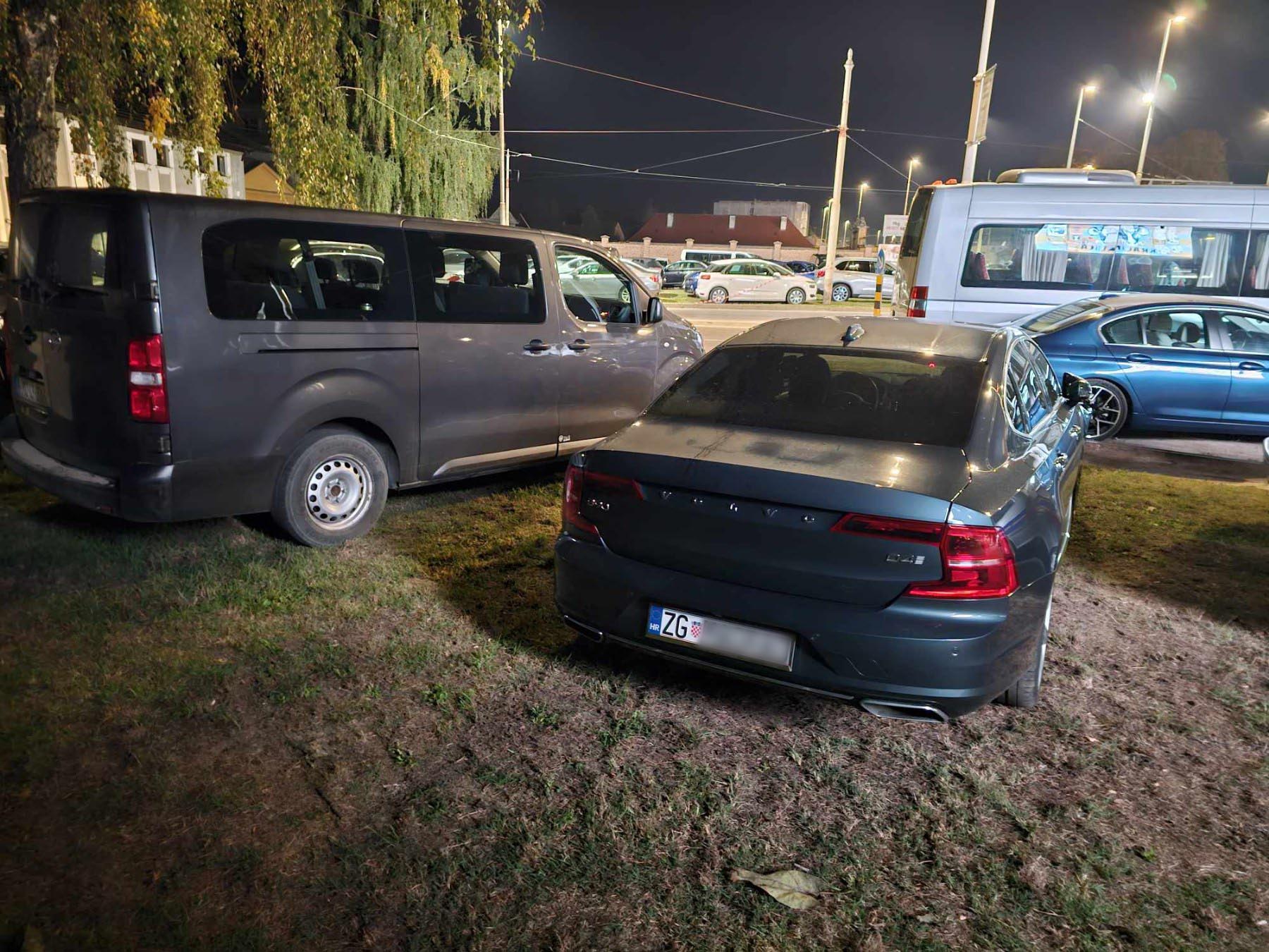 Automobili parkirani na zelenoj površini kod stadiona