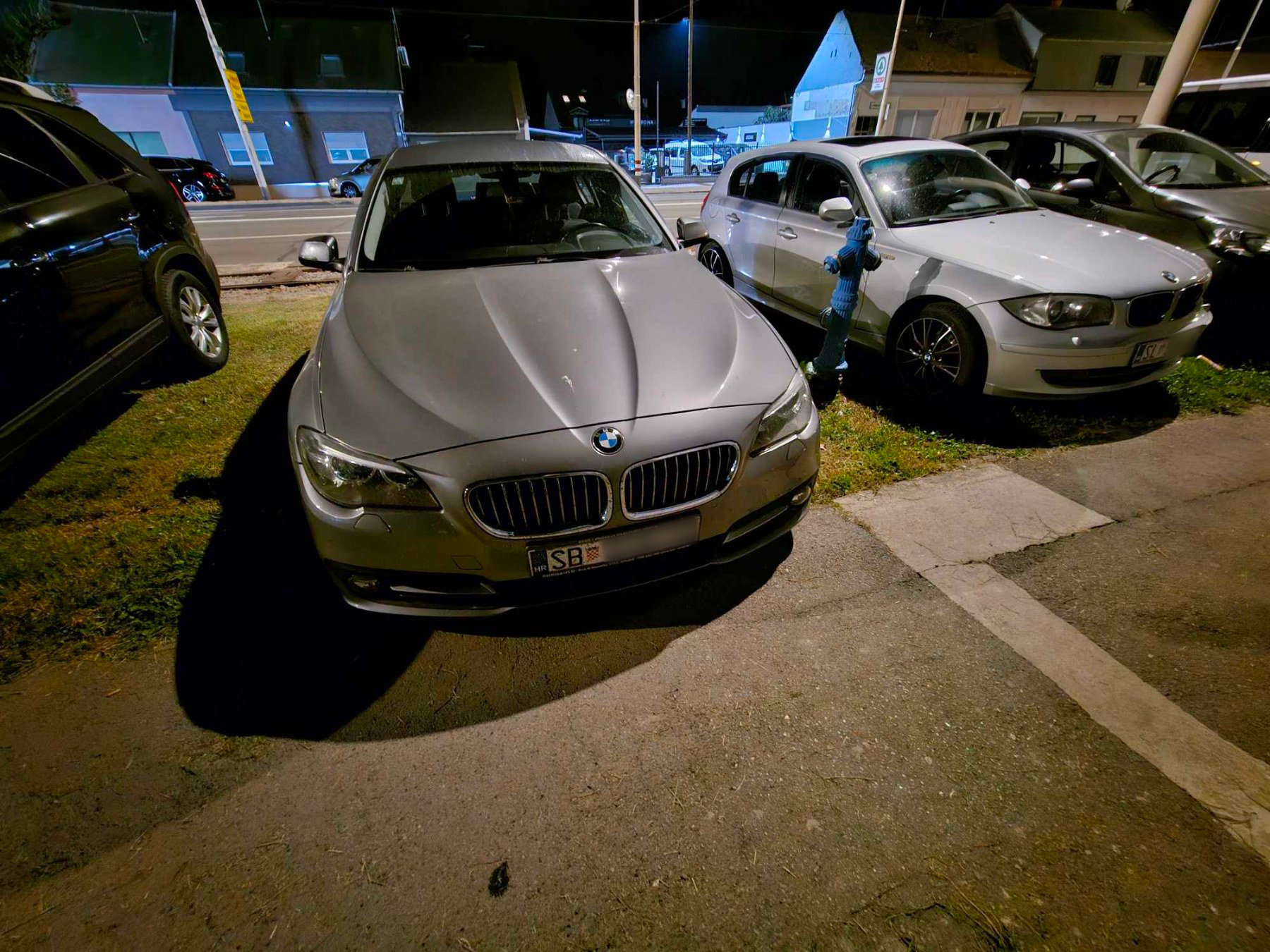 Automobili parkirani na zelenoj površini kod stadiona