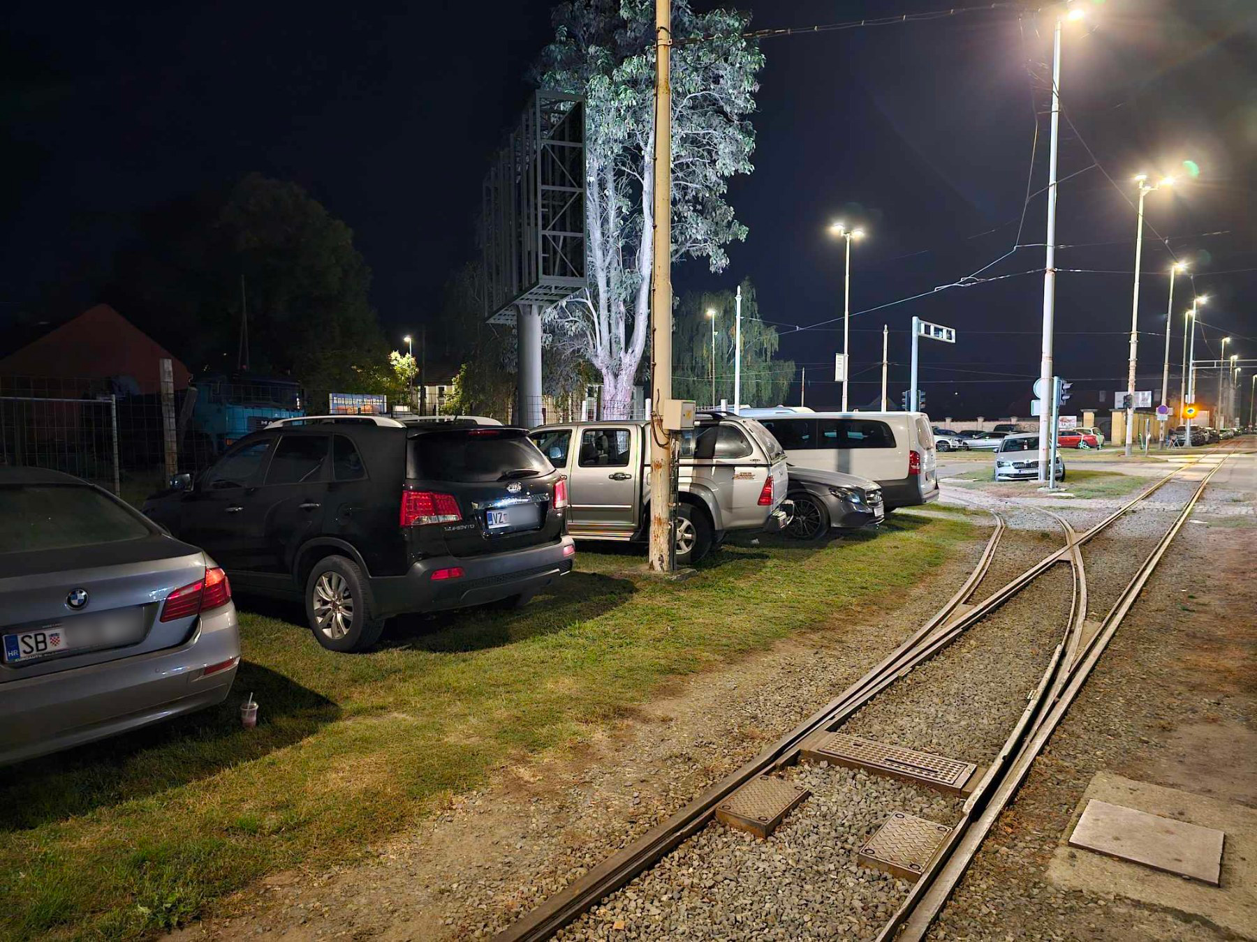 Automobili parkirani na zelenoj površini kod stadiona
